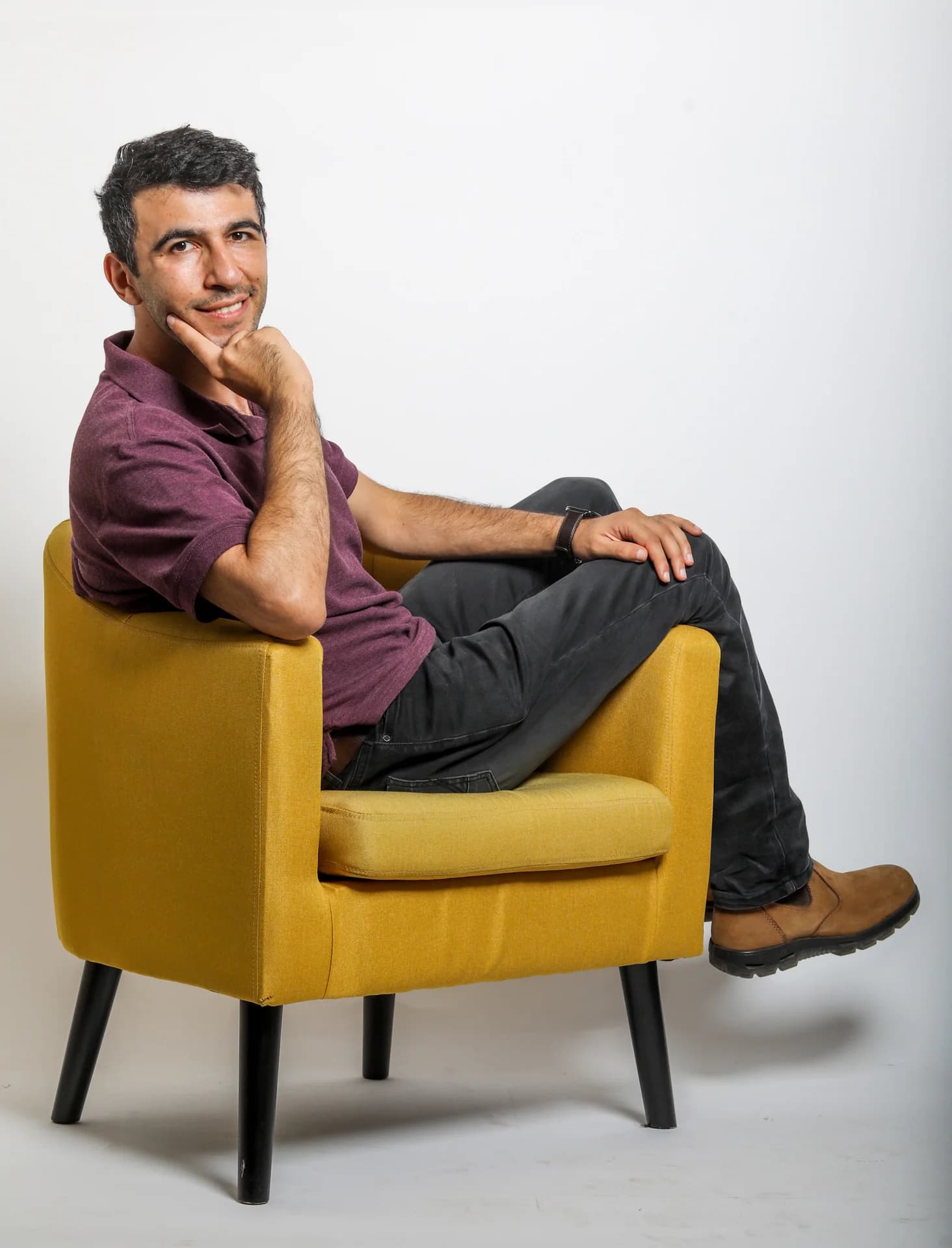 Dani Gadayev, founder of Blue Horizon 360, seated on a yellow chair